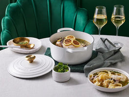 Whole poached chicken in a Le Creuset casserole, topped with lemon zest, capers and parsley