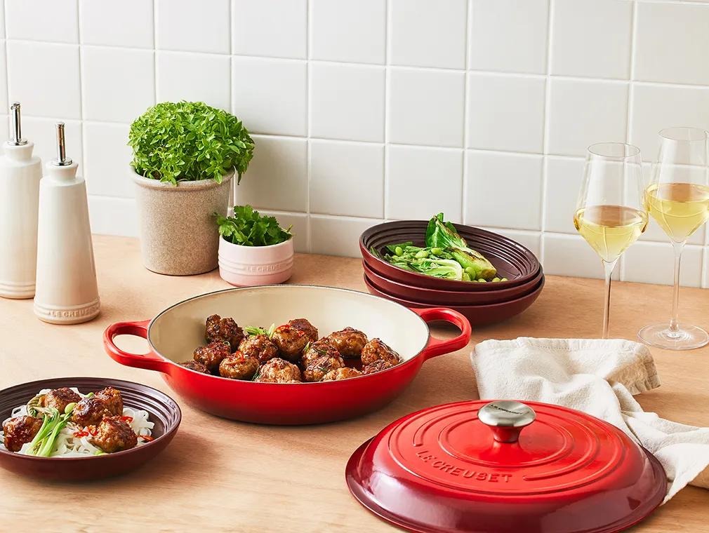 Sticky teriyaki pork meatballs served over rice with sesame seeds and spring onion