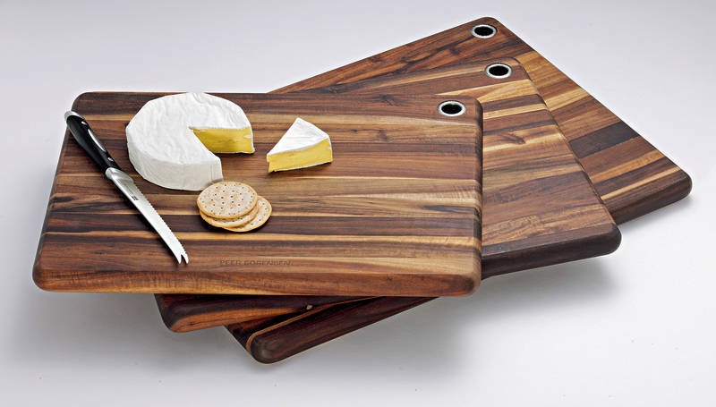 Epicurean cutting board with lime wedges, coriander, jalapeño and garlic being prepped with a knife