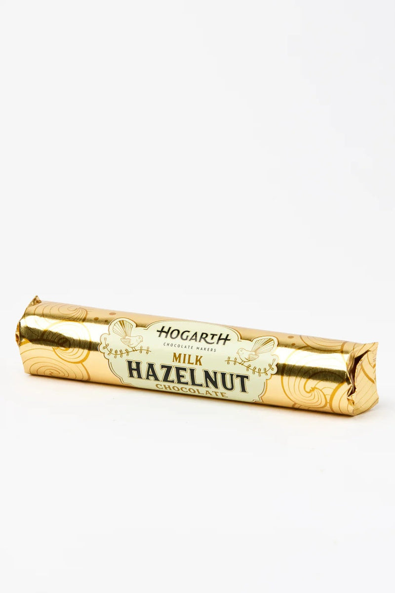 A single wrapped chocolate bar in shiny gold foil packaging with a cream label reading 'HOGARTH MILK HAZELNUT'.