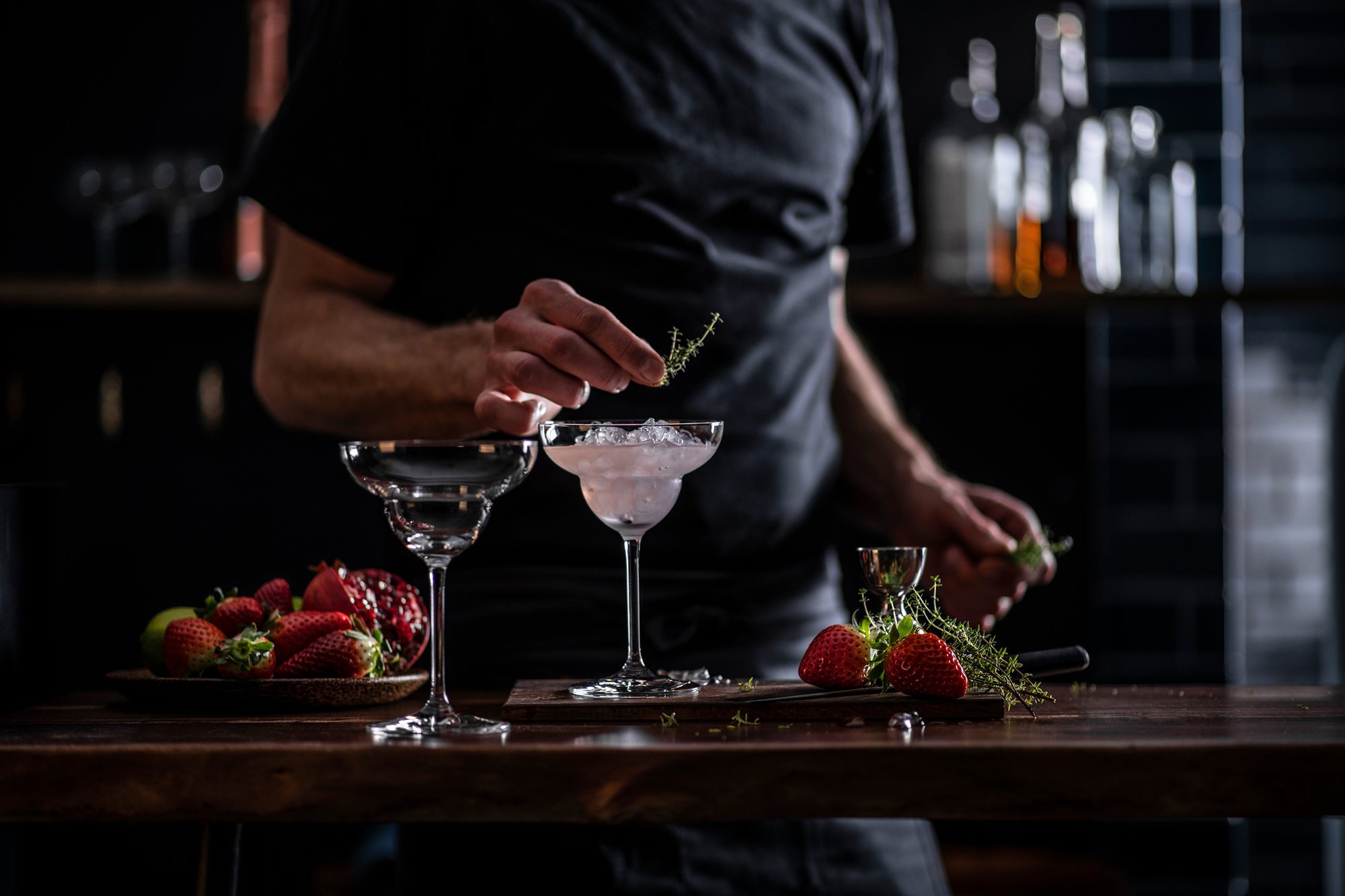 Schott Zwiesel Bar Special margarita glasses with a bartender preparing cocktails and fresh strawberries