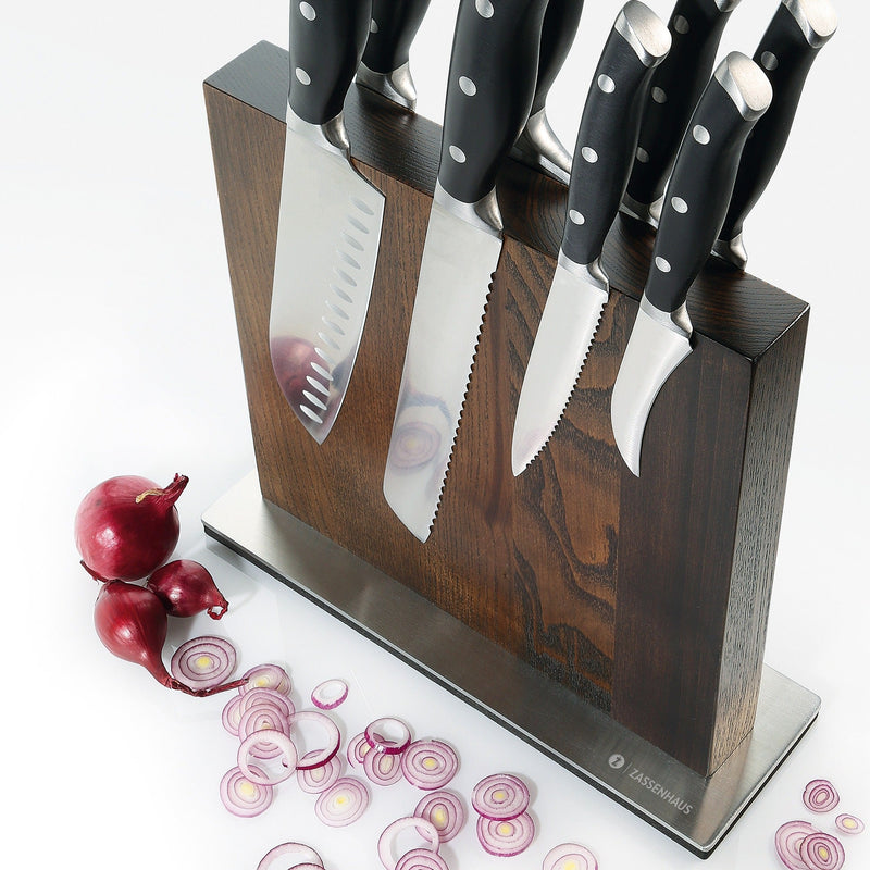 Zassenhaus dark wood magnetic knife block holding a set of black-handled knives, with sliced red onion