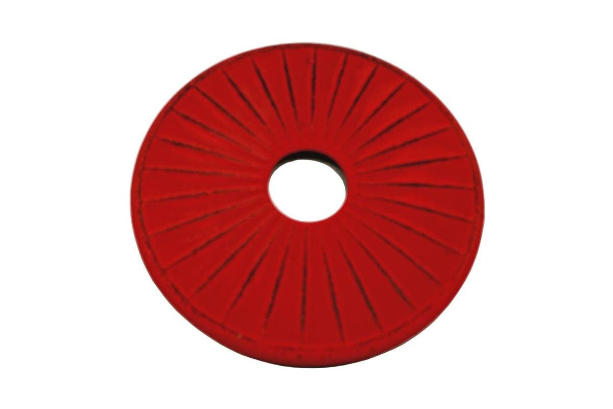 Teaology cast iron trivet in red with a ribbed pattern and a central hole