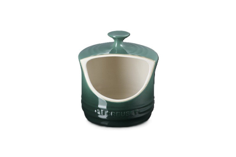 Le Creuset stoneware salt pig in green with a lid and a curved front opening