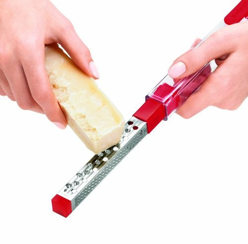 Cuisipro SGT 3-in-1 pocket grater with a red case, shown grating parmesan