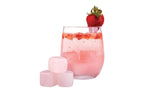Bartender Quartz Gin Stones, pink rose quartz cubes beside a pink strawberry drink in a glass
