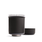 Stagg XF pour-over coffee dripper in matt black with a paper filter and a matching base