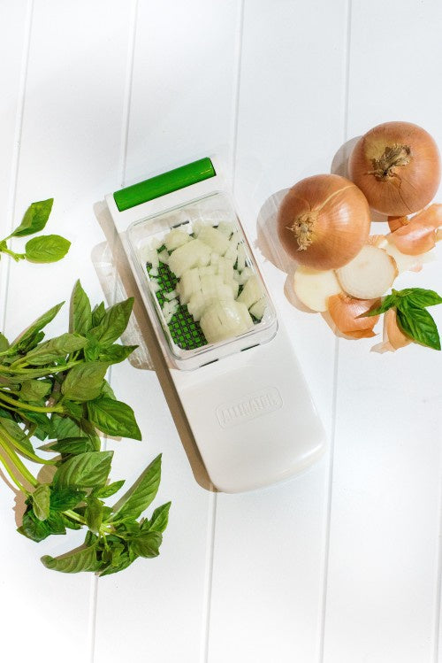 Alligator vegetable chopper with a collector, shown with chopped onion and herbs