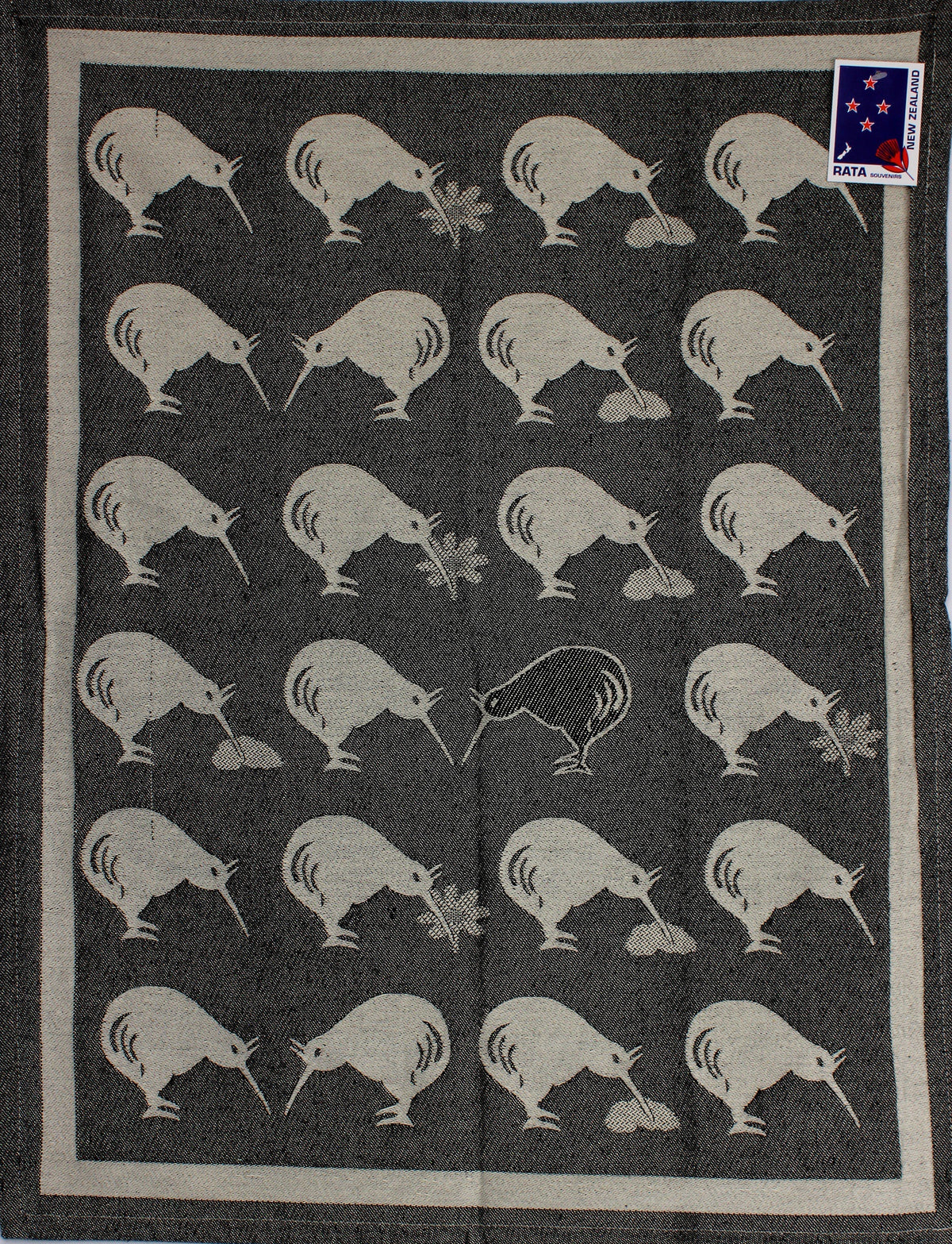 Kiwi Country tea towel in black with a repeating white kiwi bird pattern