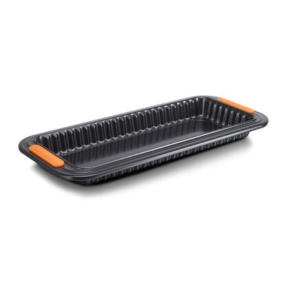Le Creuset fluted loose base tart tray in dark non-stick steel with orange handle tabs