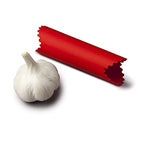 Zeal garlic peeler, a red silicone tube, shown beside a garlic bulb