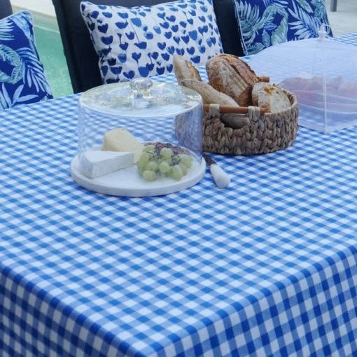 BenElke stain resistant blue gingham tablecloth, styled on an outdoor table with bread and cheese