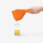 Dreamfarm Fluicer citrus juicer in orange, shown pouring juice into a glass