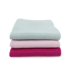 Stack of three folded blankets in light blue, pink, and magenta on a white background