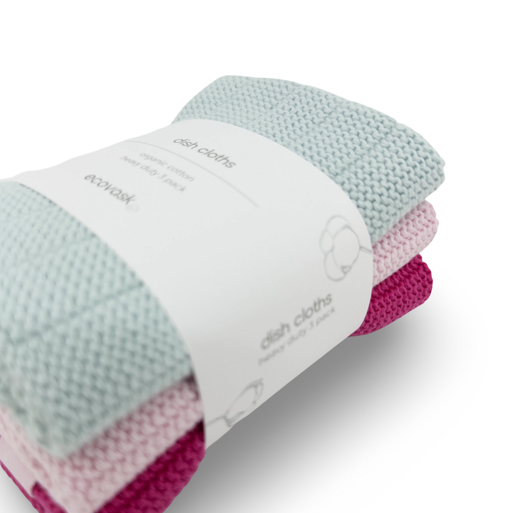 A three-pack of EcoVask hand-knit cotton dish cloths in light blue, pale pink, and magenta, wrapped in a white paper band.