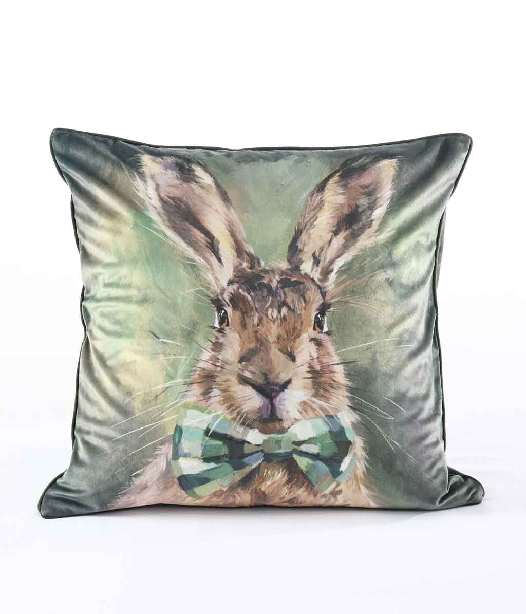 MM Linen Hare Tie cushion with a portrait of a hare in a bow tie on green velvet
