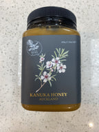 Out of The Woods Kanuka Honey jar with a dark label and floral illustration
