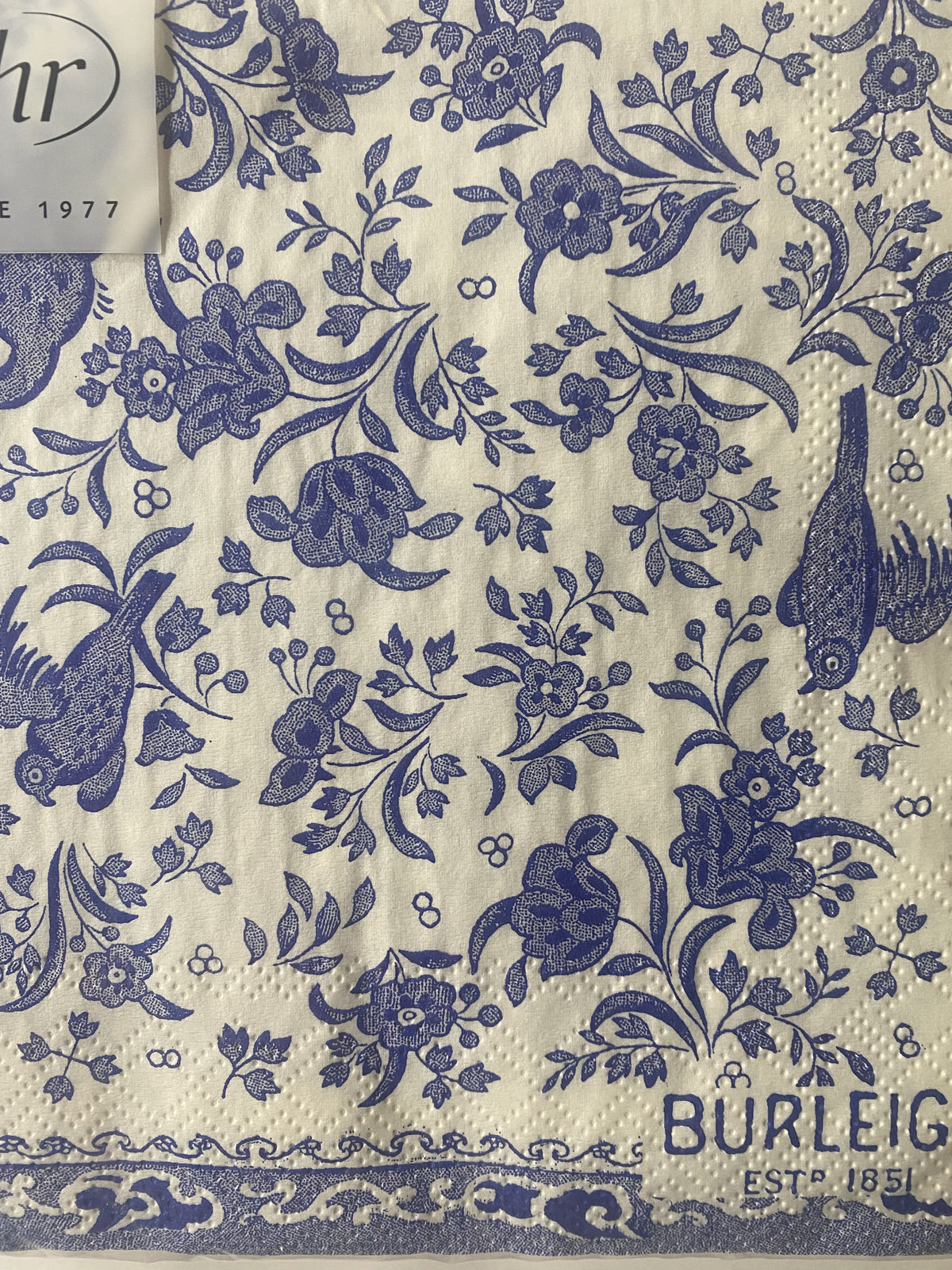 IHR luncheon napkin with a blue and cream Burleigh Regal Peacock pattern of birds and flowers