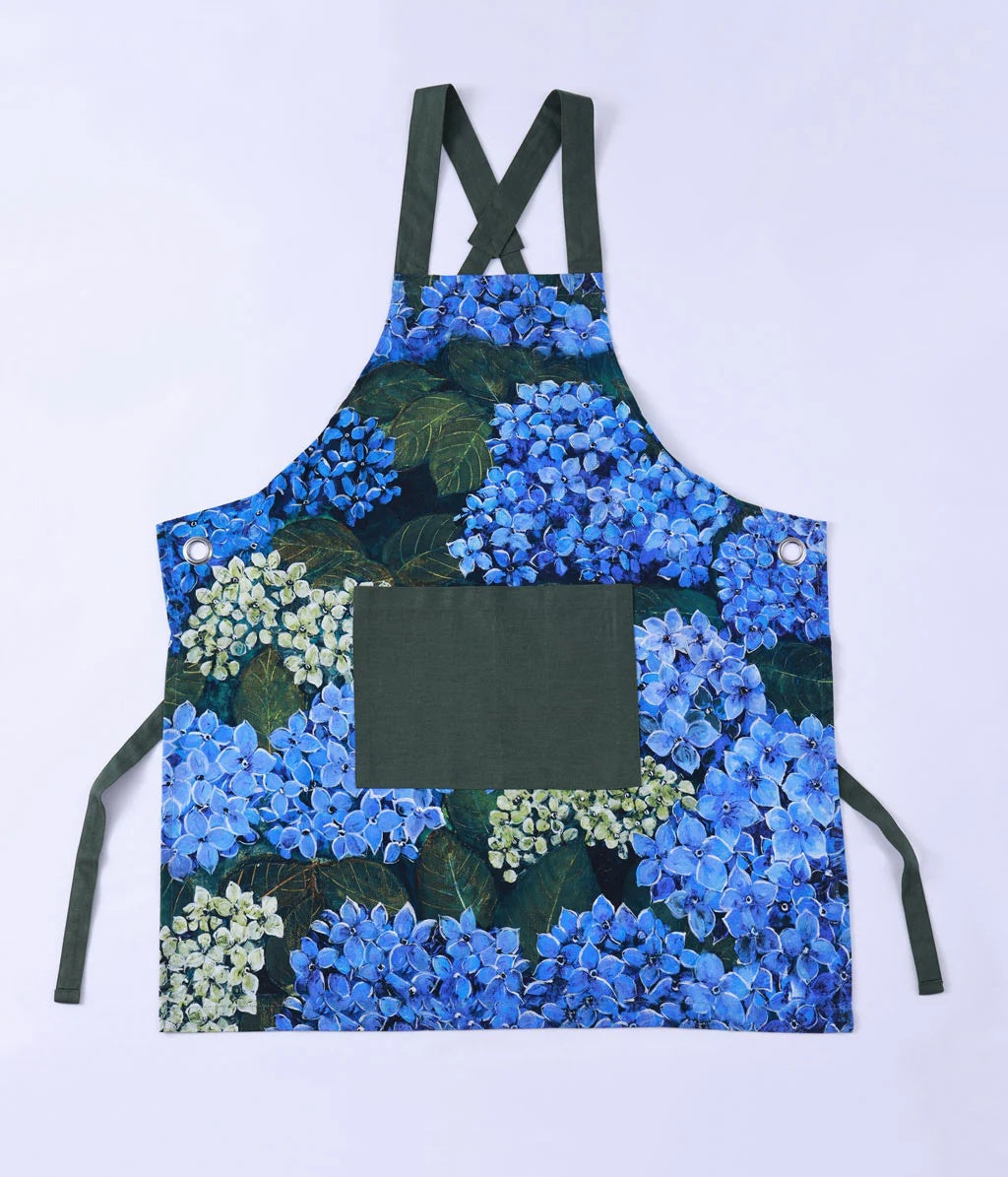 MM Linen Matilda apron with a blue hydrangea print and dark green straps