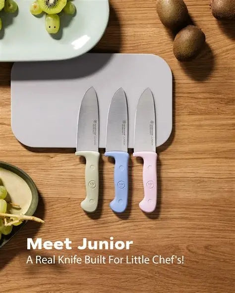 Wusthof Junior 4 inch chef's knife for children, a set of three with pastel handles, shown with kiwi fruit