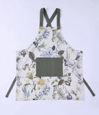 MM Linen Sanctuary apron in white with a botanical flower print and a green pocket and straps