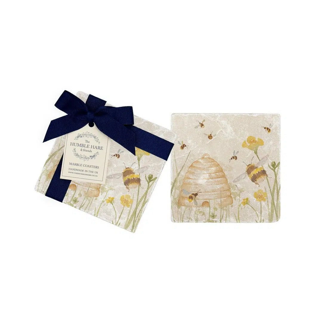 The Humble Hare Humming Hives coasters, two stone coasters with bees and a beehive, one tied with a navy ribbon