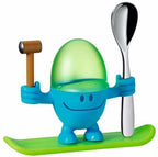 WMF McEgg egg cup, a smiling blue figure with a green egg holder, a wooden mallet and a spoon on a green board