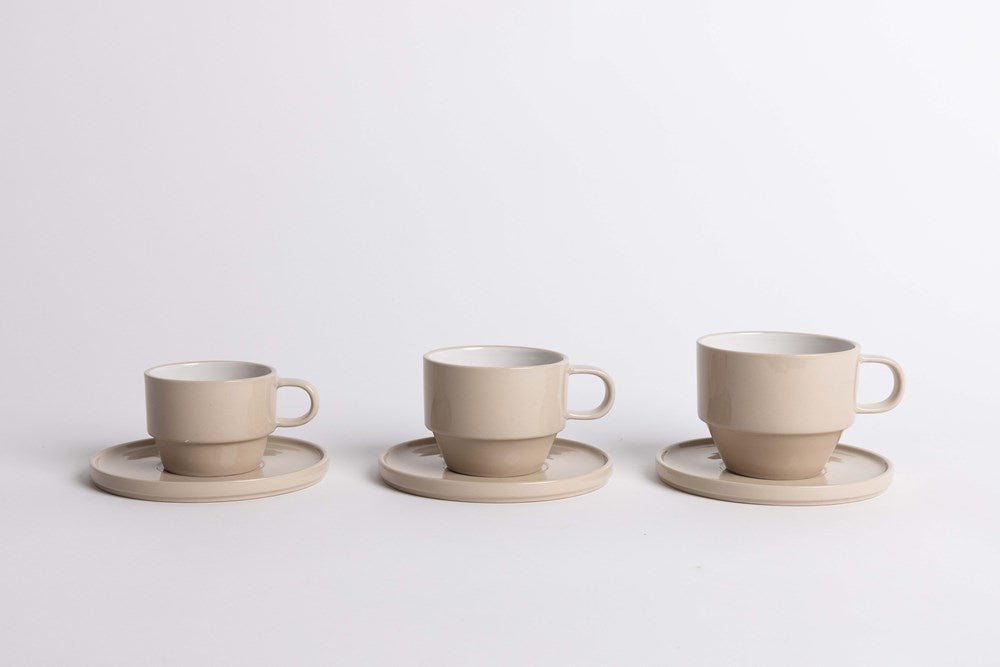Ned Collections Hudson cups and saucers in cashmere beige, three shown on a grey backdrop