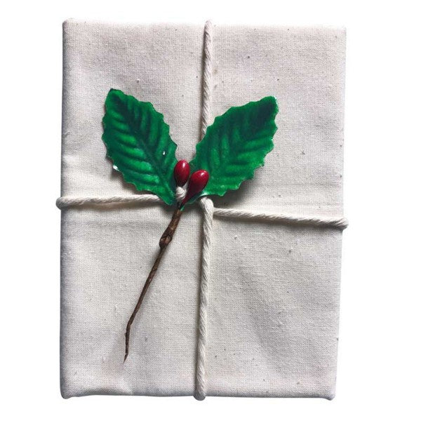 Avanti pudding cloth, a natural cotton cloth folded and tied with string and a holly sprig