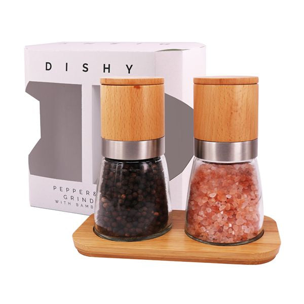 Dishy Bud salt and pepper set of two glass mills with wooden tops, on a bamboo tray in front of their box