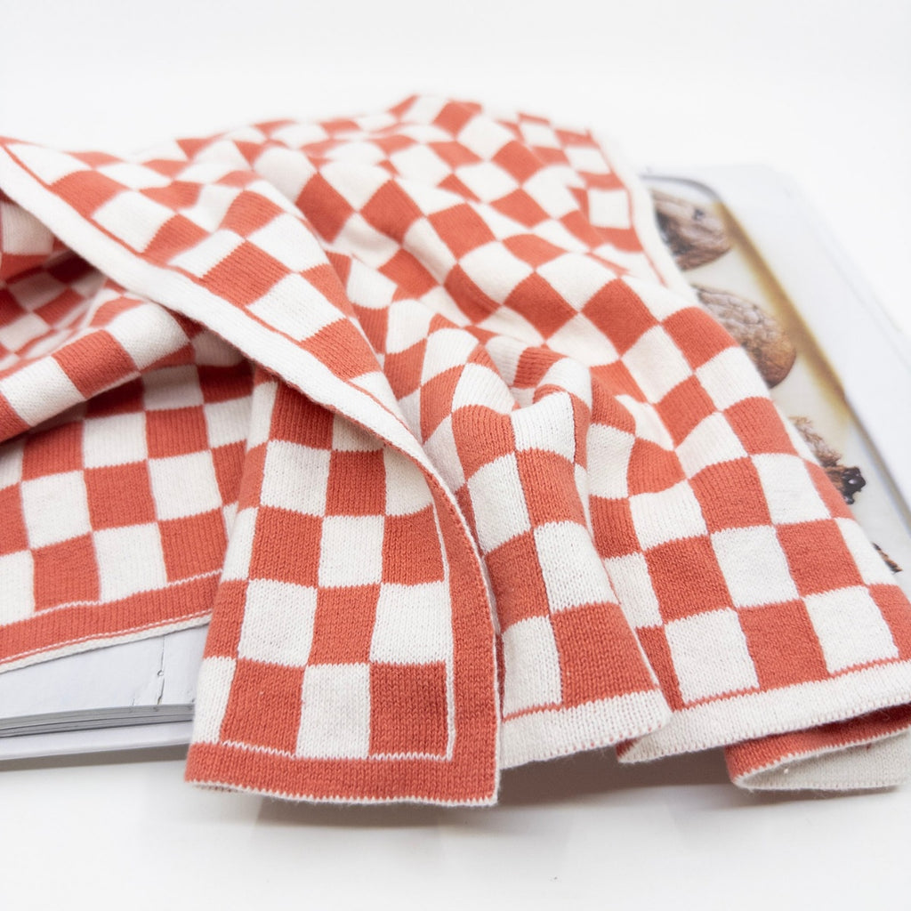 Ecovask kitchen towel in a coral and white chequer pattern, folded