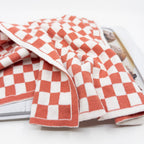 Ecovask kitchen towel in a coral and white chequer pattern, folded