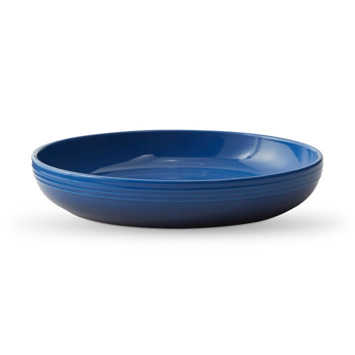 Le Creuset stoneware coupe pasta bowl in deep blue with a shallow wide shape