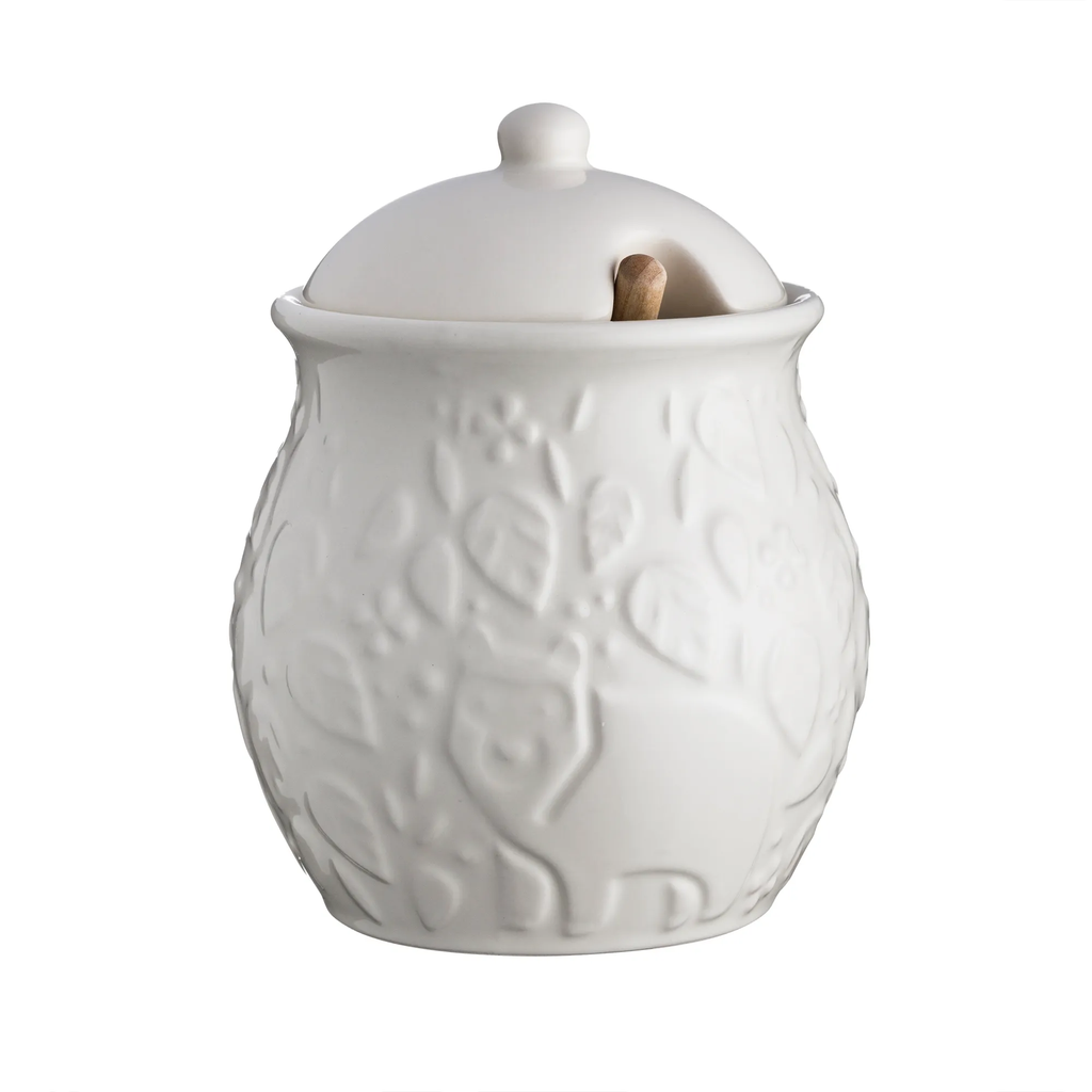 Mason Cash In The Forest honey pot in cream with an embossed woodland leaf design, a lid and a wooden dipper
