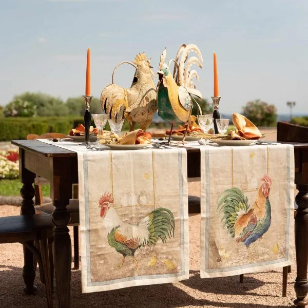Tessitura Toscana Telerie Roosters table runner styled on an outdoor table with rooster ornaments and candles