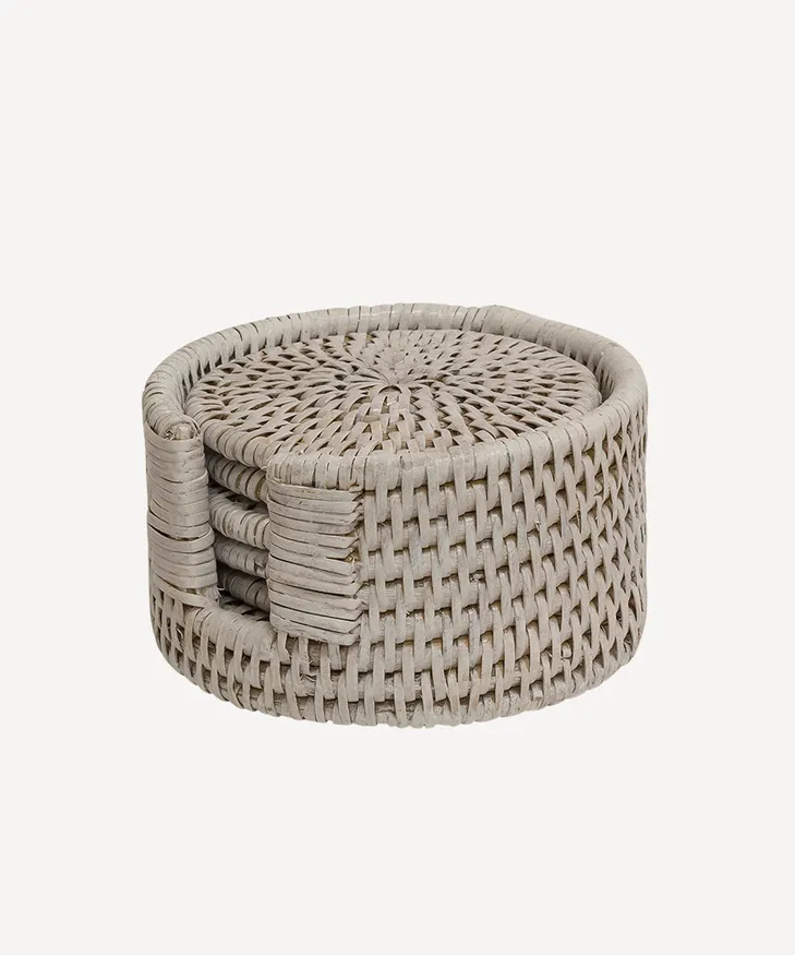 French Country Geneva rattan coaster set in grey, a stack of round coasters in a matching holder