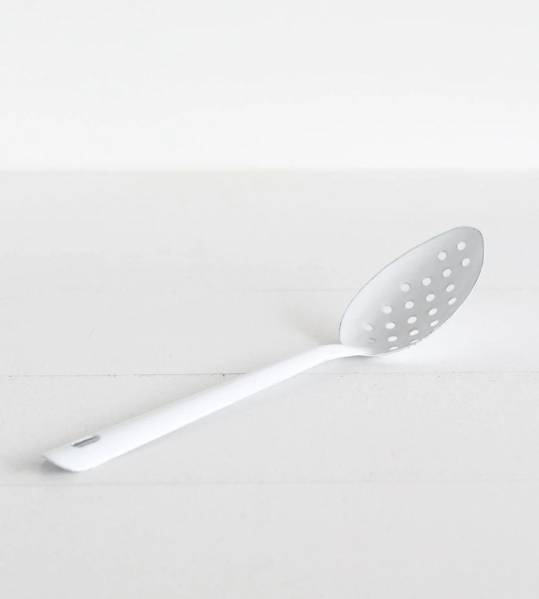 Falcon Enamelware perforated spoon in white with a long handle