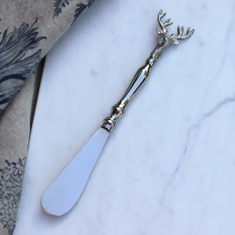 Old Mill Road elk spreader with a silver antler handle, shown on a marble surface with a napkin
