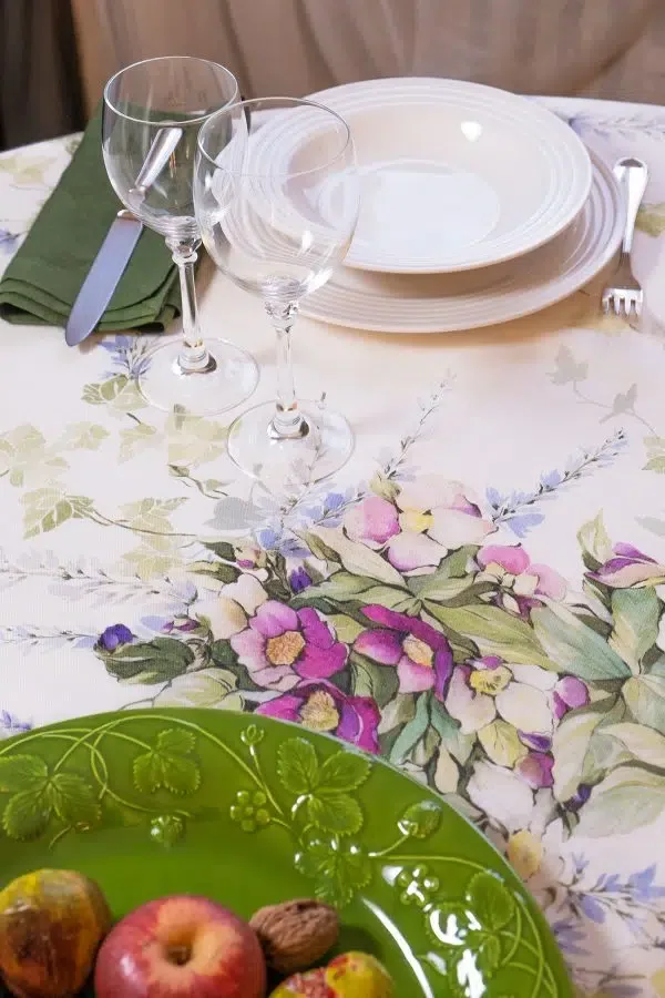 Telene Edera round linen tablecloth with a pastel floral print, styled on a set dining table