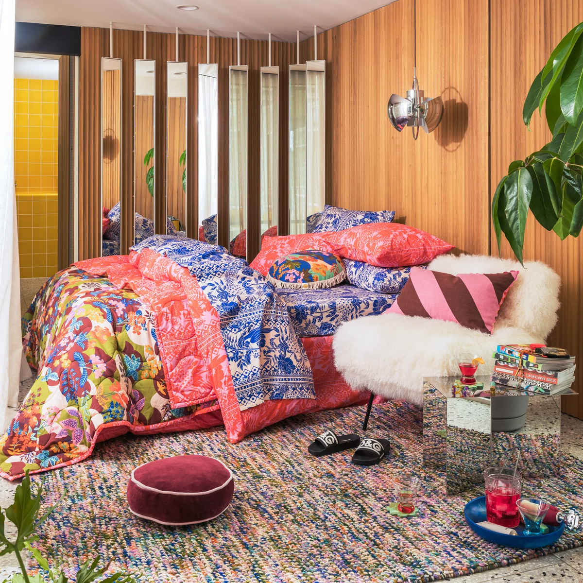 Sage x Clare Guilia Alexa coverlet, styled on a bed with mixed floral and stripe cushions