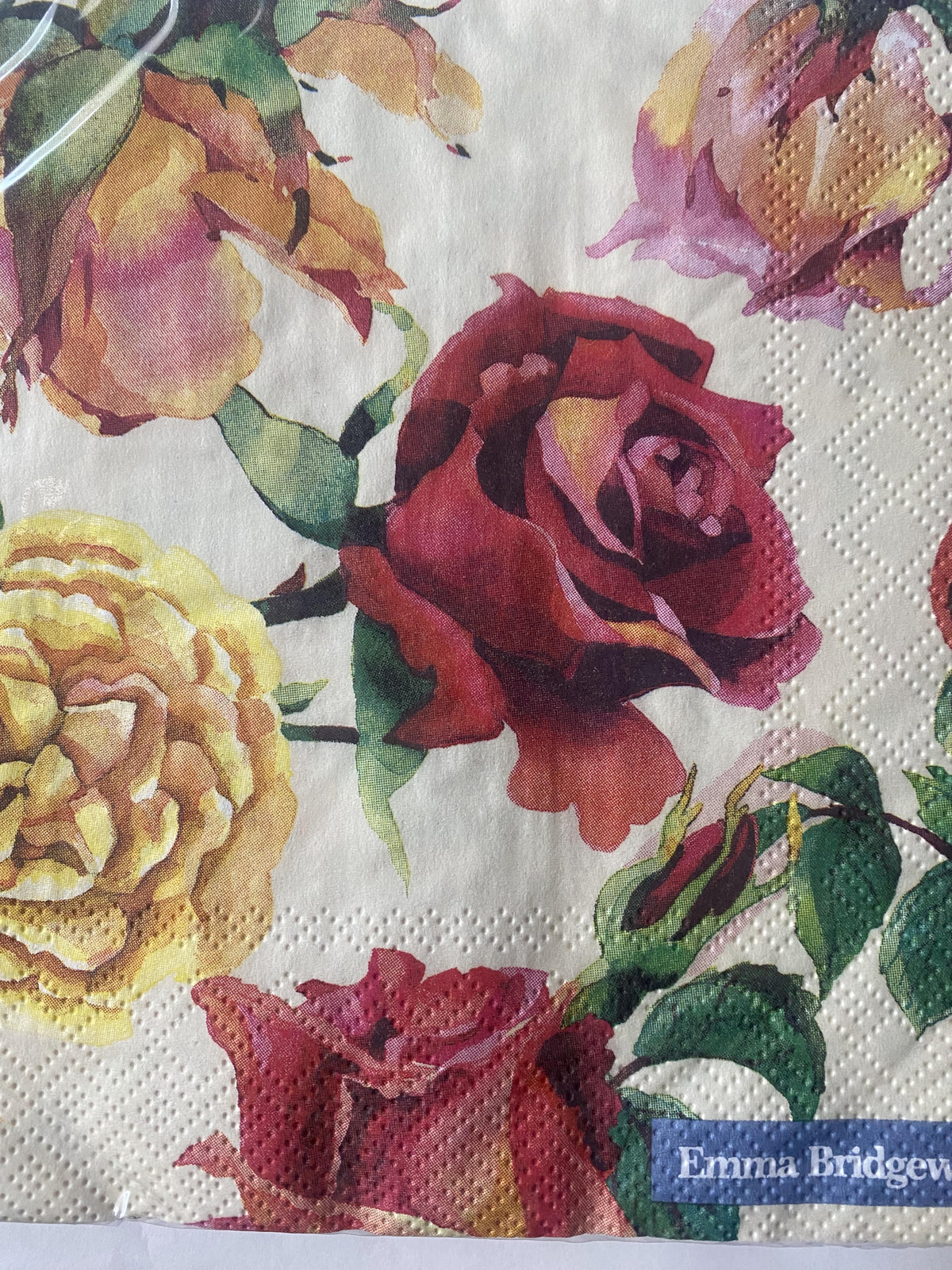 IHR luncheon napkin with an Emma Bridgewater pattern of large red, yellow and pink roses on cream